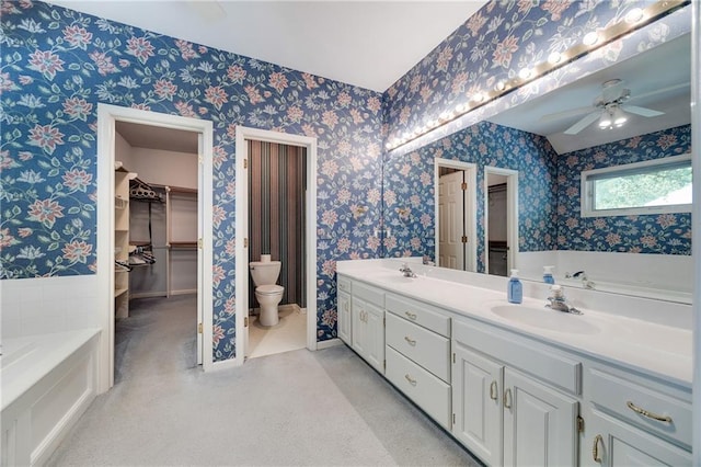 2269 SW Park Ave, Blue Springs, MO 64015 - full bathroom featuring wallpapered walls, a garden tub, double vanity, a ceiling fan, and a spacious closet