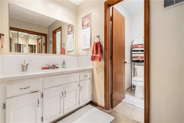 bathroom featuring backsplash, toilet, visible vents, and vanity