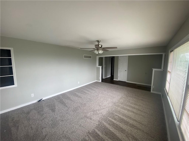 unfurnished bedroom with dark colored carpet, visible vents, a closet, baseboards, and a ceiling fan