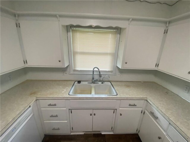 kitchen with a sink, white cabinetry, and light countertops