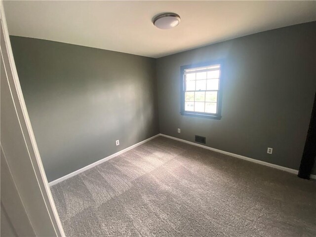 carpeted empty room featuring visible vents and baseboards