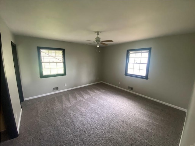 unfurnished room with visible vents, ceiling fan, carpet floors, and baseboards