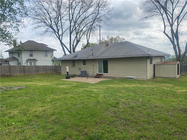 back of house featuring an outdoor structure, a yard, fence, a patio, and a shed