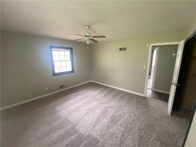 carpeted spare room featuring a ceiling fan, visible vents, and baseboards
