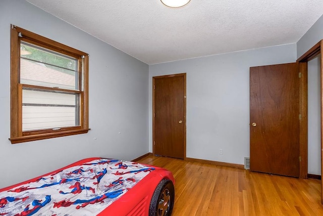 1835 Miami St, Leavenworth, KS 66048 - bedroom with wood finished floors and a textured ceiling