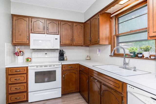 1835 Miami St, Leavenworth, KS 66048 - kitchen with white appliances, light countertops, decorative backsplash, and brown cabinetry