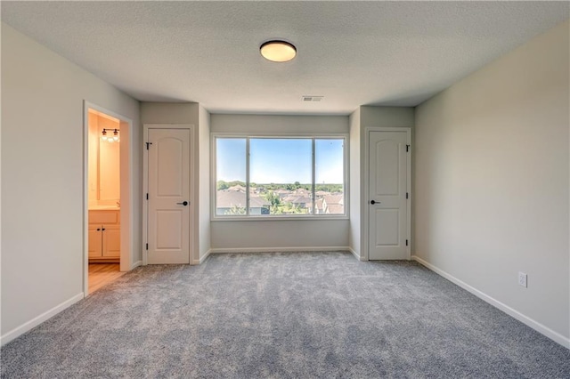 24108 W 67th Ter, Shawnee, KS 66226 - unfurnished bedroom featuring carpet, a textured ceiling, and ensuite bath