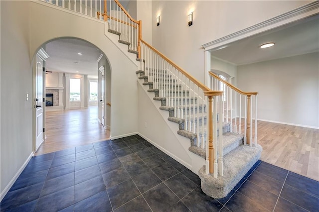 24108 W 67th Ter, Shawnee, KS 66226 - stairway featuring arched walkways, a towering ceiling, and wood finished floors