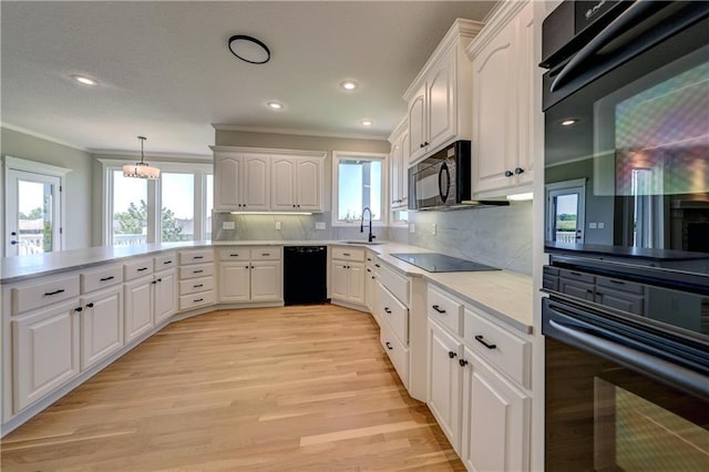 24108 W 67th Ter, Shawnee, KS 66226 - kitchen with black appliances, ornamental molding, light wood-type flooring, light countertops, and white cabinetry