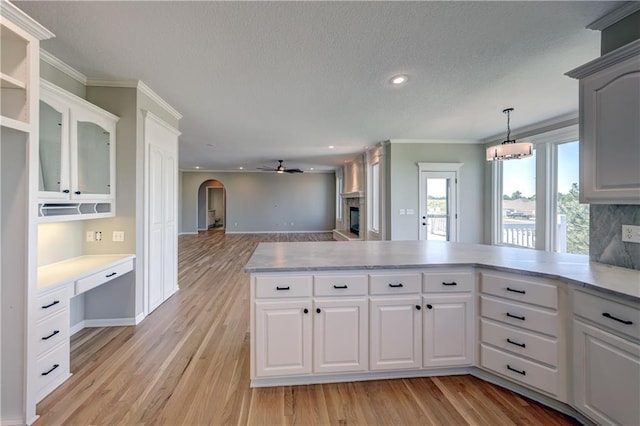 24108 W 67th Ter, Shawnee, KS 66226 - kitchen featuring crown molding, light countertops, a textured ceiling, arched walkways, and a peninsula