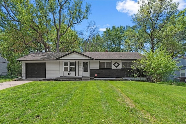 ranch-style home featuring an attached garage, concrete driveway, and a front yard