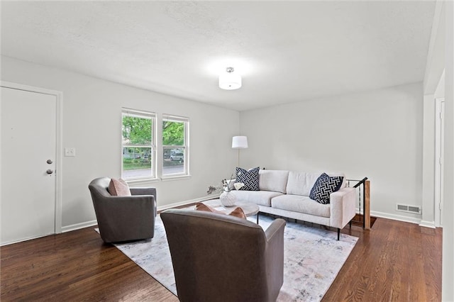 living area with baseboards, wood finished floors, and visible vents