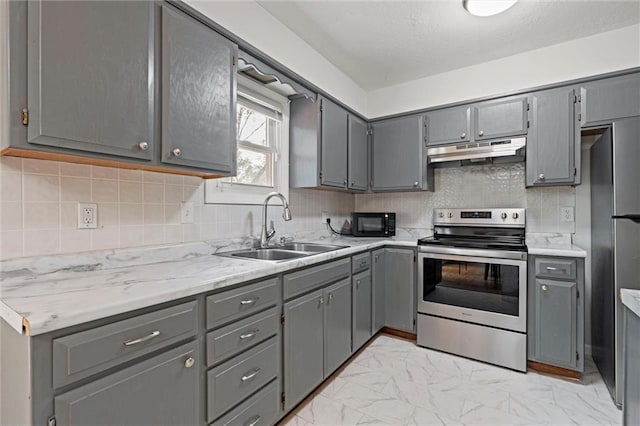 kitchen featuring marble finish floor, gray cabinets, under cabinet range hood, a sink, and stainless steel appliances