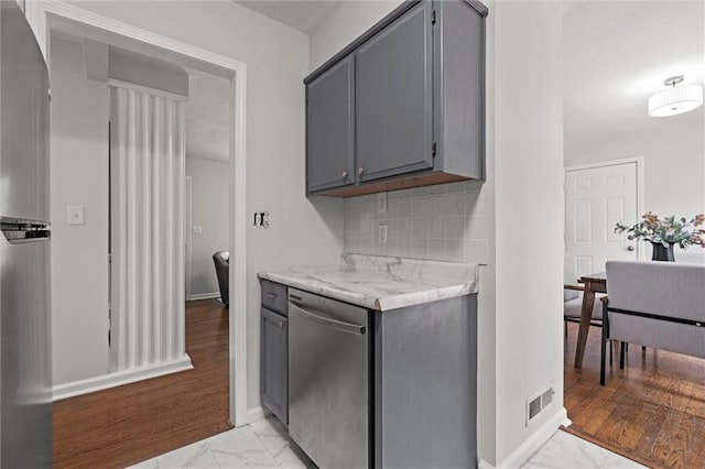 kitchen with visible vents, stainless steel dishwasher, marble finish floor, light countertops, and gray cabinets