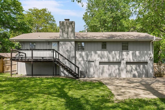 2427 N 83rd Ln, Kansas City, KS 66109 - rear view of property featuring a chimney, an attached garage, stairway, driveway, and a shingled roof
