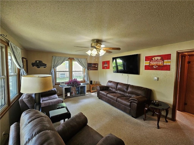 carpeted living area with a ceiling fan and a textured ceiling