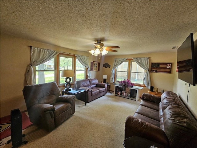 living room with light carpet, a textured ceiling, and ceiling fan