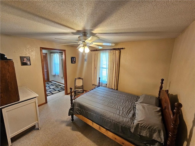 bedroom featuring a textured ceiling, multiple windows, ceiling fan, and light carpet