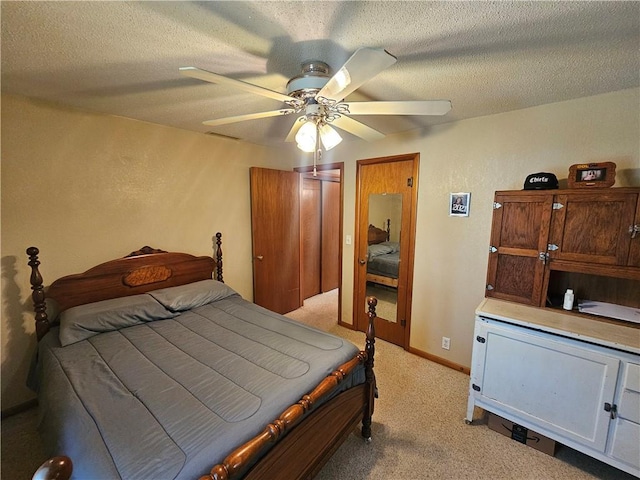 bedroom with a ceiling fan, light carpet, and a textured ceiling