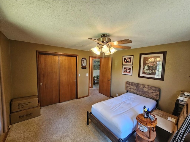 carpeted bedroom with a textured ceiling, a ceiling fan, and a closet