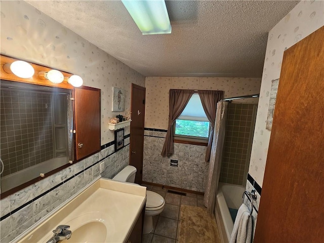 full bathroom featuring wallpapered walls, toilet, a textured ceiling, and tile patterned flooring