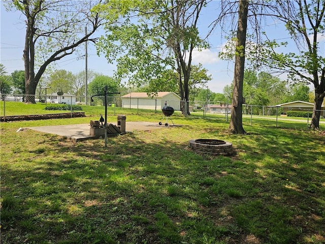 view of yard with fence and an outdoor fire pit