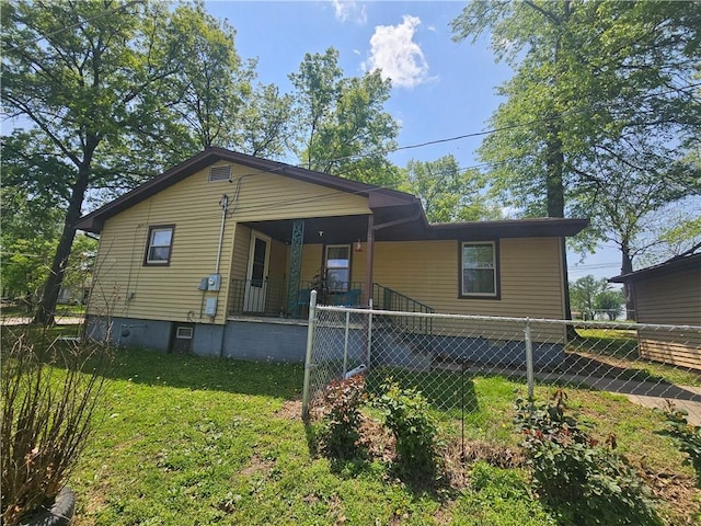 back of property featuring fence, a lawn, and a porch