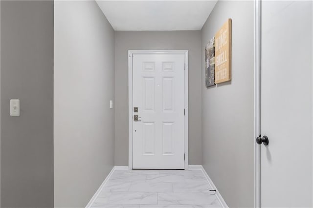 doorway with baseboards and marble finish floor