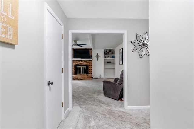 hall with baseboards, carpet, and built in shelves