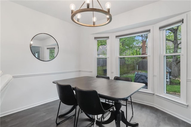 dining room featuring an inviting chandelier, baseboards, plenty of natural light, and dark wood finished floors