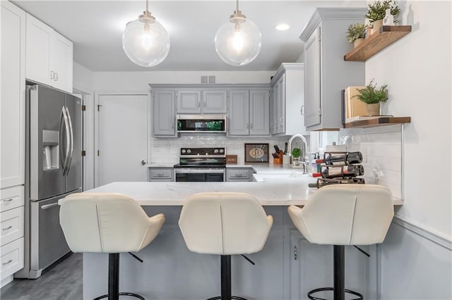 kitchen featuring light countertops, a sink, backsplash, and stainless steel appliances