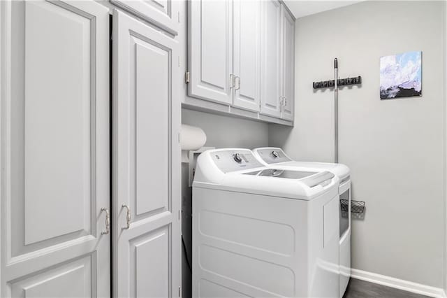 clothes washing area with baseboards, cabinet space, and washing machine and clothes dryer