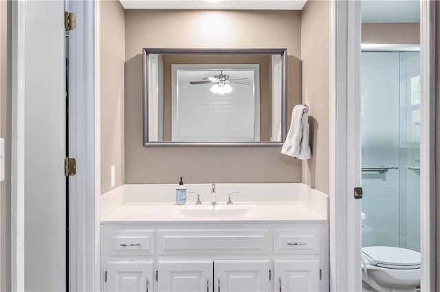 full bathroom featuring vanity, a shower with shower door, and toilet