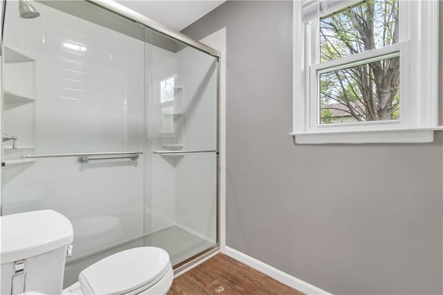 bathroom featuring plenty of natural light, baseboards, wood finished floors, and toilet