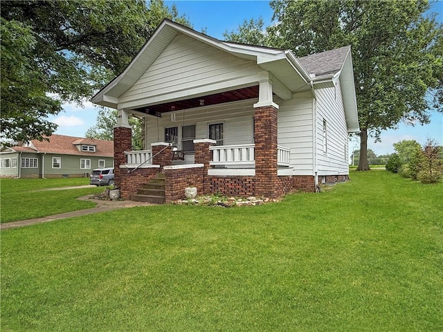 601 W 22nd St, Higginsville, MO 64037 - view of front of home featuring covered porch, a front lawn, and roof with shingles