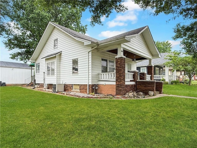 601 W 22nd St, Higginsville, MO 64037 - view of side of home featuring central AC, a yard, and a porch