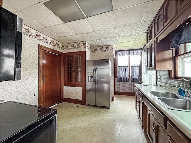 601 W 22nd St, Higginsville, MO 64037 - kitchen with stainless steel refrigerator with ice dispenser, wallpapered walls, black / electric stove, a sink, and light countertops