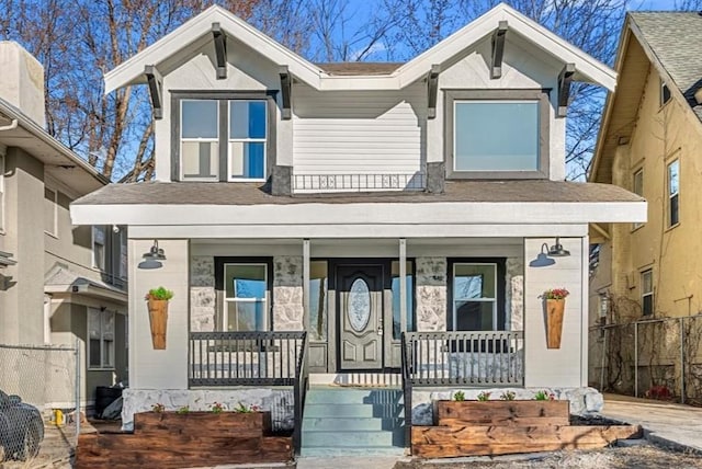 view of front of property featuring fence and a porch