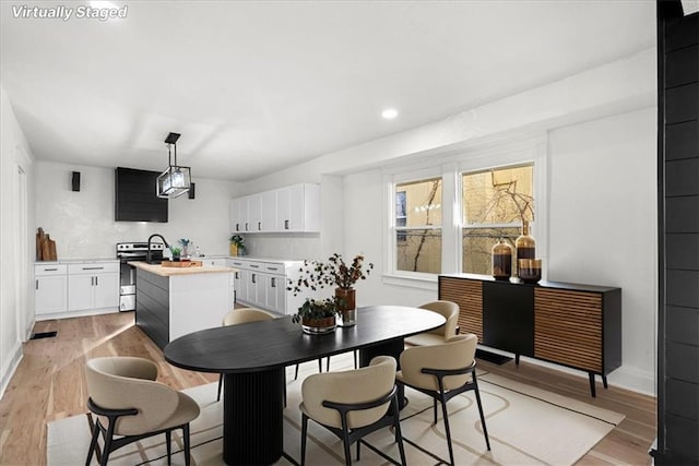 dining area featuring baseboards, recessed lighting, and light wood-style floors