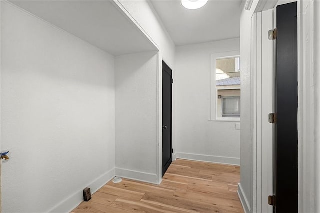 corridor featuring baseboards and light wood-style floors