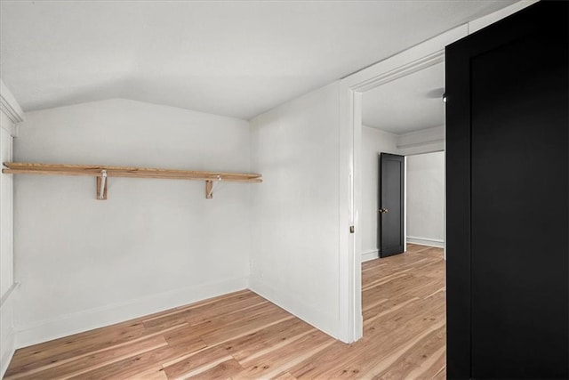 walk in closet with light wood-style flooring and lofted ceiling