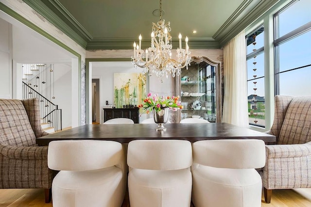 dining space featuring crown molding, wood finished floors, and a chandelier