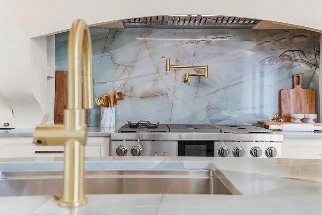 kitchen with decorative backsplash, white cabinetry, and light countertops