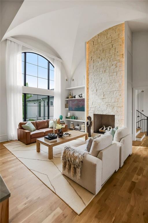 living area with wood finished floors and high vaulted ceiling