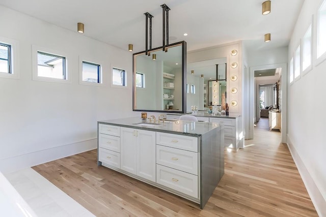 full bathroom with vanity, baseboards, and wood finished floors
