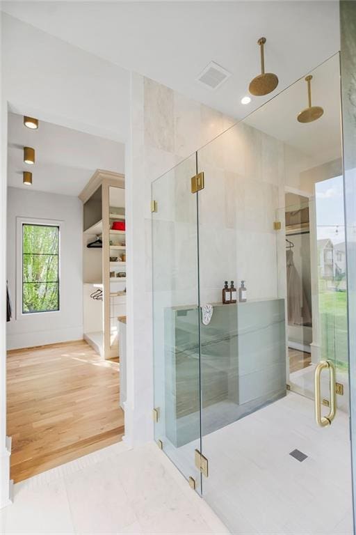 bathroom featuring visible vents, wood finished floors, and a shower stall