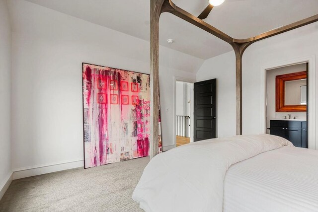 carpeted bedroom featuring ceiling fan, baseboards, vaulted ceiling, and a sink