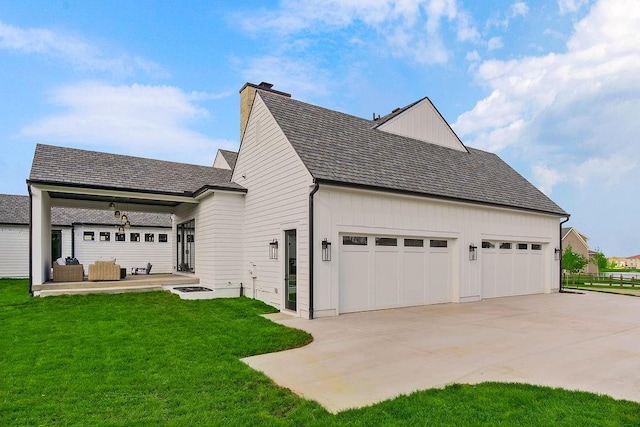 view of property exterior featuring board and batten siding, an outdoor living space, a chimney, driveway, and a yard