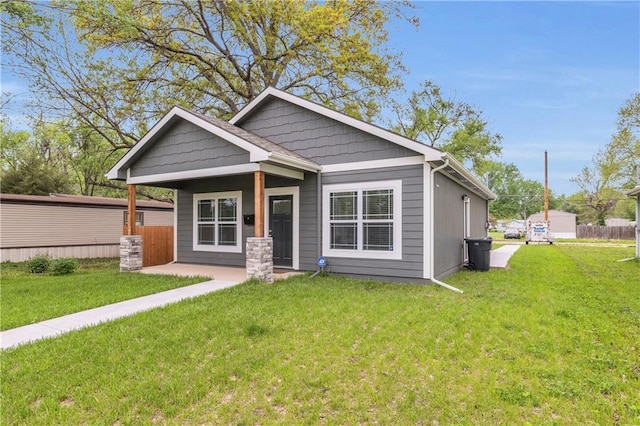 view of front facade featuring a patio, fence, and a front yard