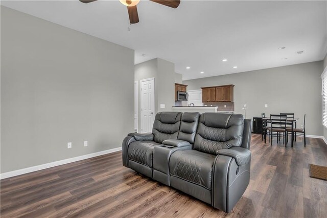 living area featuring recessed lighting, a ceiling fan, dark wood-style flooring, and baseboards